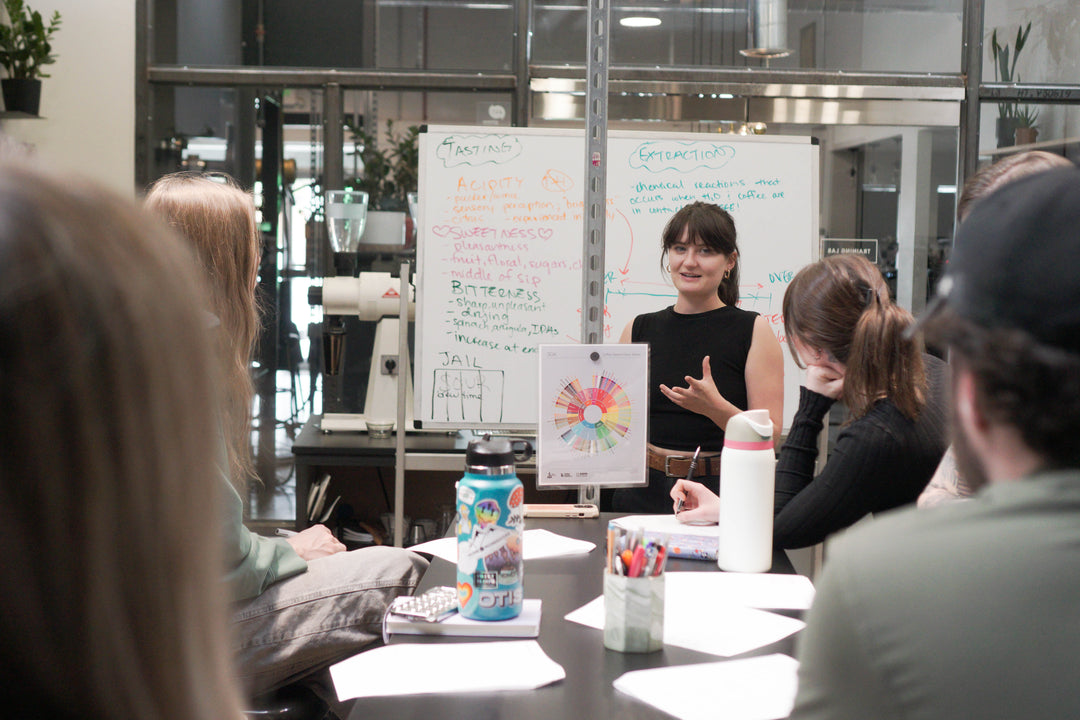 Person presenting in a meeting room with a whiteboard and participants.