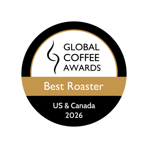 A circular award badge for the Global Coffee Awards Best Roaster 2026, US & Canada. The badge is black and white with a gold horizontal band across the center.