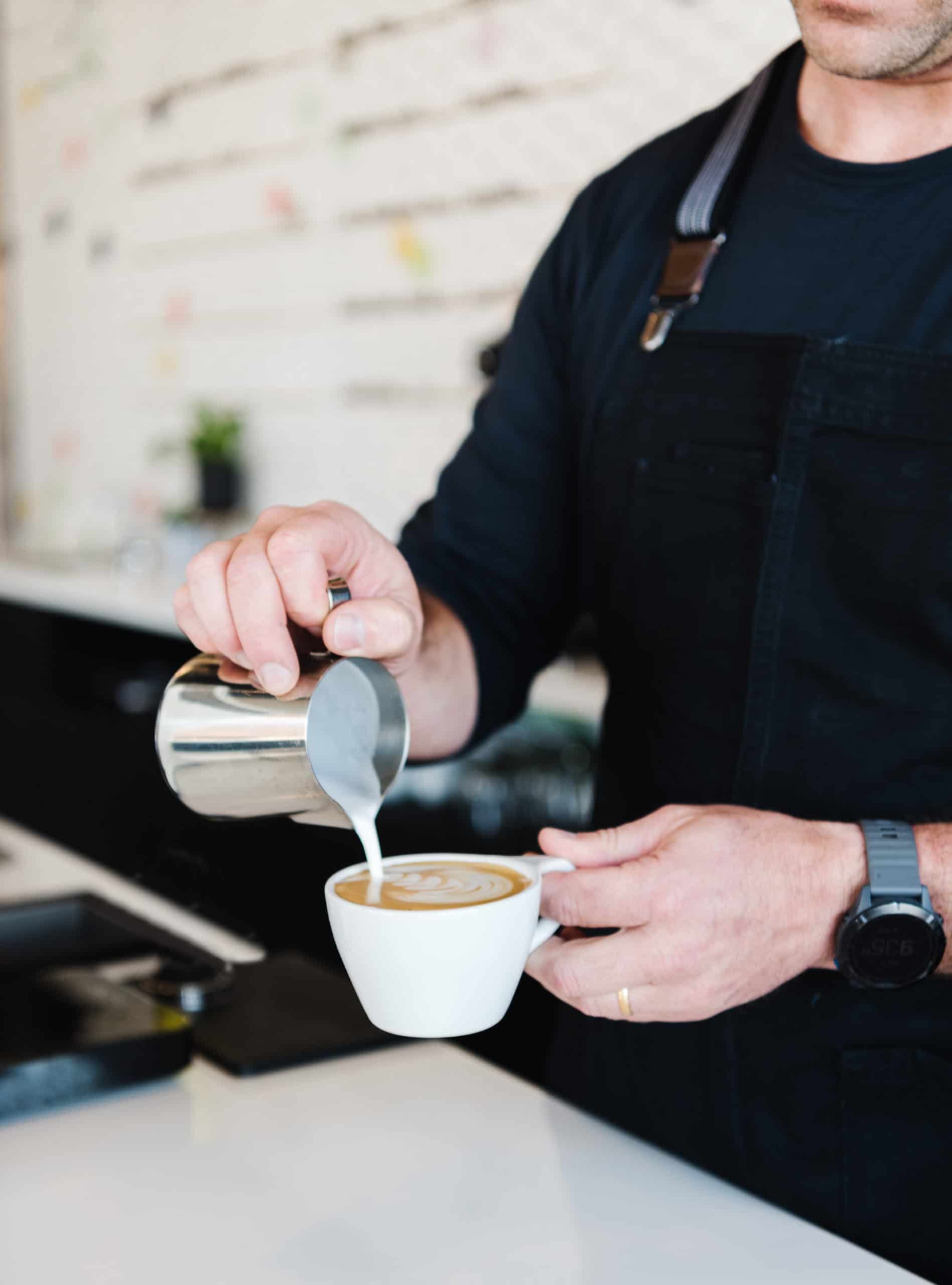 Barista pouring latte art at our Westminster Cafe