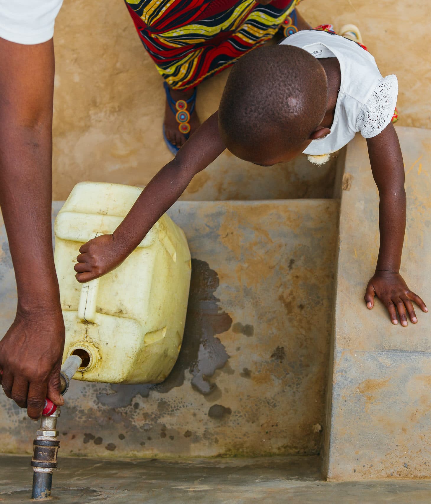 Rwandan people getting fresh water from a community faucet