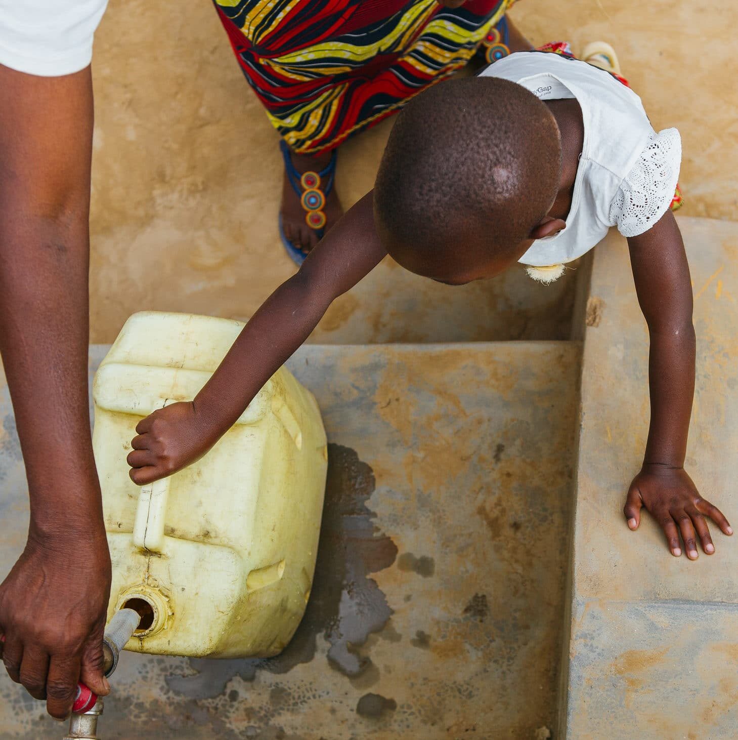 Rwandan people getting fresh water from a community faucet