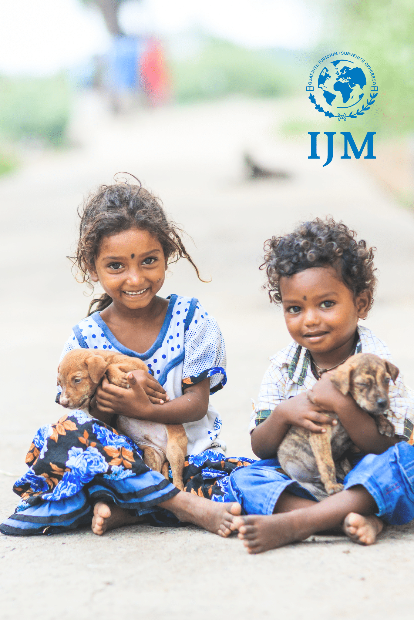 kids sitting while holding puppies in their laps smiling